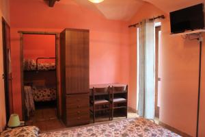 安泰伊-萨伊恩特-安德尔埃Locanda monte cervino的一间卧室设有橙色的墙壁、梳妆台和镜子