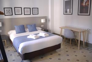 格拉纳达La Perla Granada Suites的配有一张床和一张书桌的酒店客房