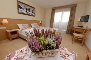波兰尼卡-兹德鲁伊阿尔贝耶斯基酒店的一间酒店客房,配有床和鲜花