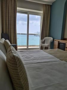 比尔泽布贾Water's Edge Hotel的一间卧室配有一张床,享有海景