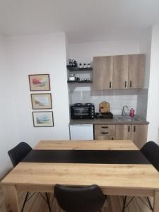 索科矿泉村Apartman Marko的厨房配有木桌和两把椅子