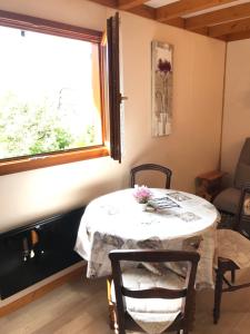 Saint-Offenge-DessousAux Paniers Coussins HOMALYS的窗户客房内的桌椅