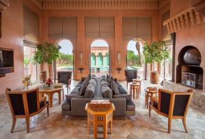 马拉喀什Amanjena Resort的客厅配有沙发和桌椅
