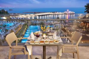 欧库卡拉Mylome Luxury Hotel & Resort - Ultra All Inclusive的阳台上的餐桌和食物,享有海景