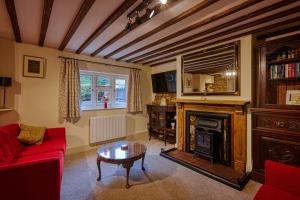 Fab 2 Bed Cotswolds Cottage with Private Courtyard的客厅设有红色的沙发和壁炉