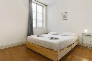 巴约讷Flat in the historic heart 2min to the river - Bayonne - Welkeys的卧室配有一张带白色床单的大床和窗户。