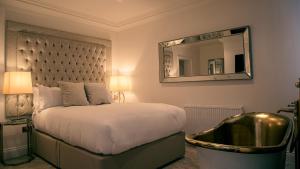 切斯特The Hotel Chester的一间卧室配有一张带镜子和浴缸的床