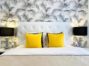 马德里Palacio Apartments Madrid的一间卧室配有白色床和黄色枕头