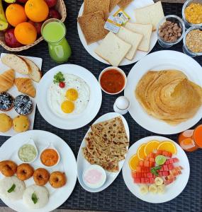 贝尔高姆Regenta Resort Belagavi的餐桌上摆放着早餐食品和饮料