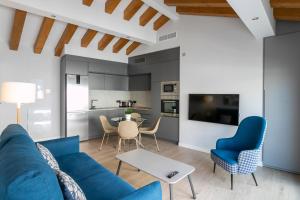 阿利坎特Arenal Suites Alicante的客厅配有蓝色的沙发和桌子