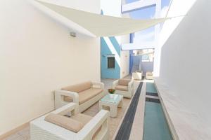 梅伦杜尼奥Residence Borgo & Mare - Localo的客厅配有白色家具和游泳池