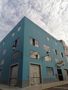 特鲁希略Suite Trujillo的蓝色的建筑,侧面有四扇车库门