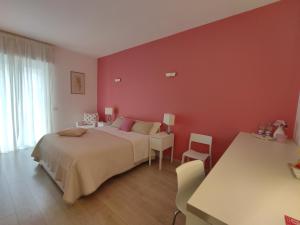孔韦尔萨诺Dimora Francesca的红色卧室配有床和桌椅