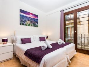 马略卡岛帕尔马Mallorca Suites - Turismo de Interior的卧室设有一张白色大床和一扇窗户。