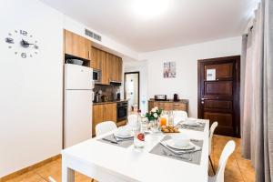 马略卡岛帕尔马Mallorca Suites - Turismo de Interior的厨房配有白色桌子和白色冰箱。
