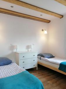 卢托维斯卡Apartamenty Pod Lipą的一间带两张床和白色梳妆台的卧室