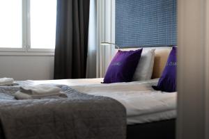 RaisioHotelli Loimu的酒店客房配有两张带紫色枕头的床