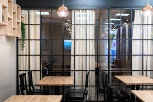 RaisioHotelli Loimu的餐厅设有木桌、椅子和玻璃墙