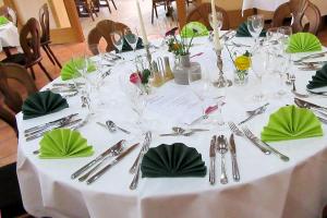 比克堡Jetenburger Hof的一张带绿色餐巾和银器的白色桌子
