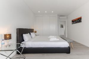 MariquiteiraChill House - Luxury house的一间卧室配有一张床和一张玻璃桌