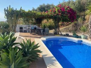 阿里纳斯Belvilla by OYO Villa in Arenas with Private Pool的庭院中的游泳池,带桌子和鲜花
