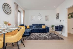 圣奥尔本斯LillyRose Serviced Apartments - St Albans City Centre的客厅配有蓝色的沙发和桌子