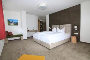 贝希特斯加登贝希特斯加登艾尔斌酒店的卧室配有一张白色大床和一把椅子