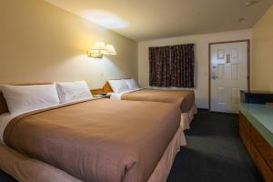 坎卢普斯坎卢普斯朗奇兰汽车旅馆的酒店客房设有两张床和窗户。