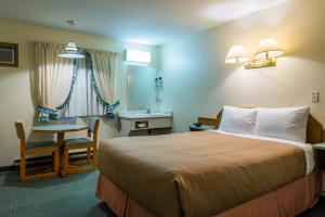 坎卢普斯坎卢普斯朗奇兰汽车旅馆的酒店客房,配有一张床、一张桌子和椅子