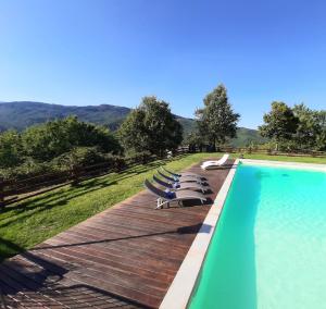 SalutioVilla Galearpe with private pool in Tuscany的木制甲板上带躺椅的游泳池
