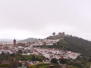 科迪加纳Vivienda Rural Olivar del Chanza的山顶上的一个小镇,有城堡