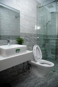 大叻Peony Hotel的浴室配有卫生间、盥洗盆和淋浴。