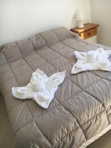 玛德琳港Departamento Centrico VDL的床上有两条白色毛巾