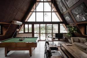 恩纳LOGIN OKINAWA -wood-的带大窗户的客房内的台球桌