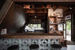 恩纳LOGIN OKINAWA -wood-的厨房配有柜台和一些凳子