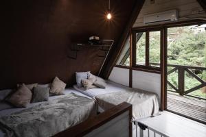 恩纳LOGIN OKINAWA -wood-的客房设有两张床和窗户。
