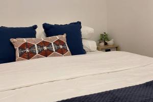 凯阿玛Kiama Palms on Collins的一张带蓝色和白色枕头的床