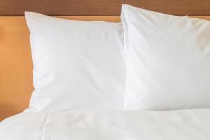 横滨横滨洲际大酒店的一张带白色床单和枕头的床