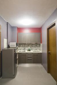 马尼拉2 Bedroom Condo Unit Fully Furnished的带冰箱和红色墙壁的厨房