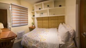 马尼拉2 Bedroom Condo Unit Fully Furnished的一间卧室配有一张床、一张书桌和一个窗户。