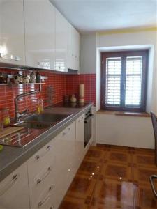 法扎纳Apartments Zukanovic的厨房配有白色橱柜、水槽和窗户。
