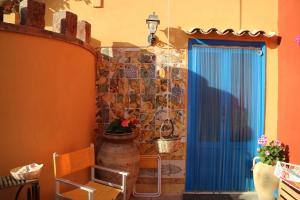 特拉帕尼都卡笛卡斯尔蒙特酒店的一间设有蓝色门和石墙的房间