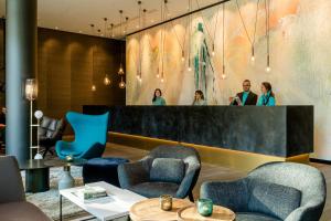 科隆Motel One Köln-Neumarkt的一个带椅子的大堂和一个带镜子的酒吧