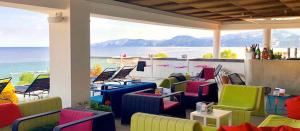 卡拉古诺内Hotel Cala Luna的一个带五颜六色椅子的海景庭院
