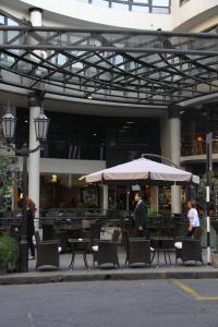 圣米格尔·德·图库玛图库曼中心商务套房酒店的一间带桌椅和遮阳伞的餐厅