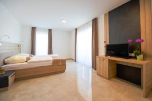 斯姆勒尼科HOTEL BARON的一间卧室配有一张床和一台平面电视