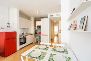 阿尔么丽亚Trendy Homes Almería的厨房配有餐桌和红色冰箱
