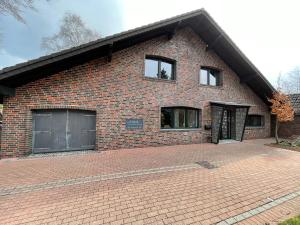 蒙绍Haus Wunschlos Auf Aderich的砖屋,带两个窗户,砖车道