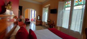锡切斯瑙赛迪斯塔酒店的一间卧室配有一张带红色枕头的床和一扇窗户