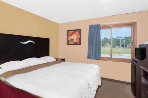 希博伊根希伯根普利德速8酒店的一间卧室设有一张大床和一个窗户。